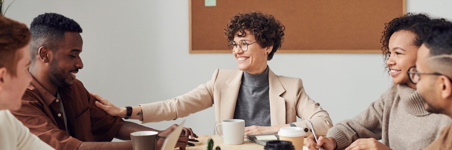 A group of people sat around a table having a business meeting